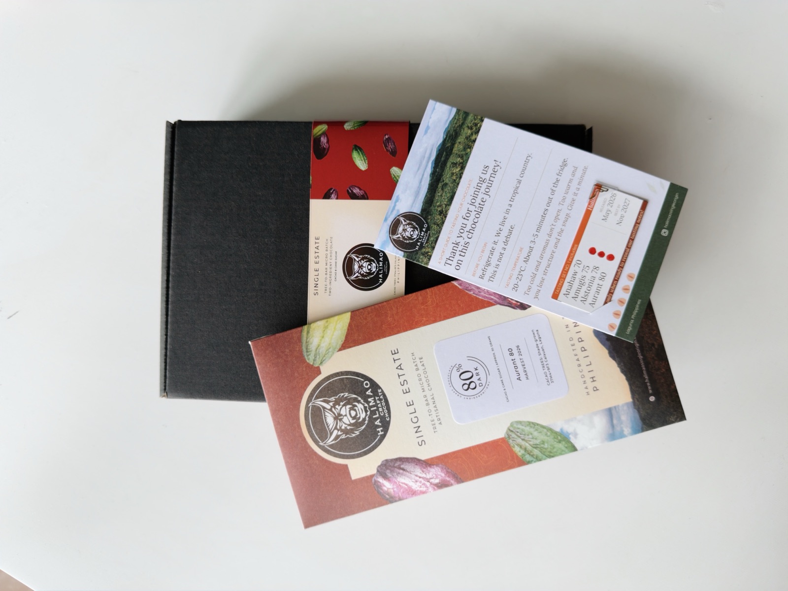 The Halimao debut-drop packaging: the kraft box, a wrapped bar, and the tasting card